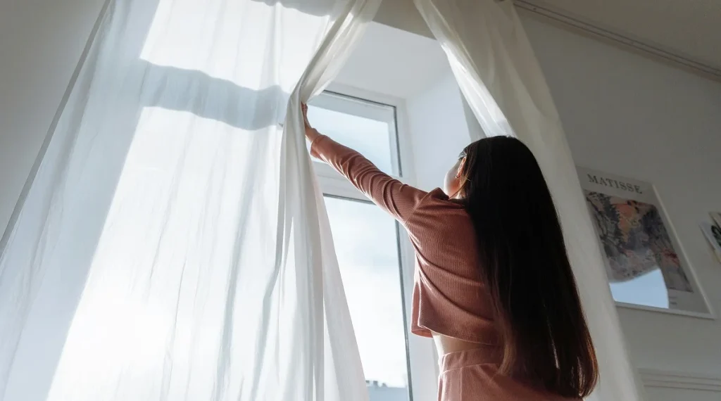 Using daylight better by opening curtains to reduce lighting demand in a home interior