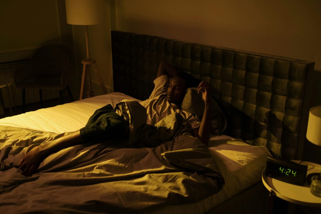 Warmer nights affecting sleep as a person uses a fan in a bedroom