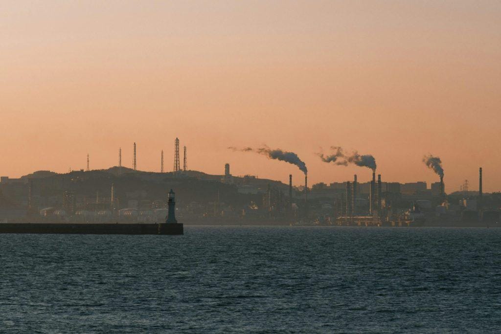 Poor air quality over an industrial urban shoreline at sunset