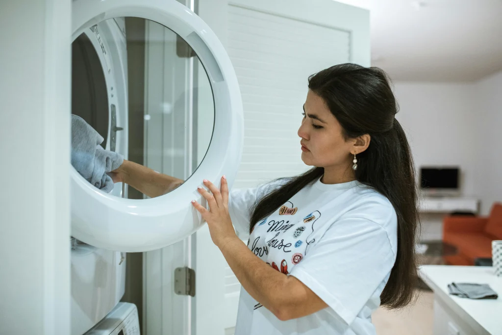 Drying clothes earlier in the day in a laundry room to help reduce indoor heat buildup