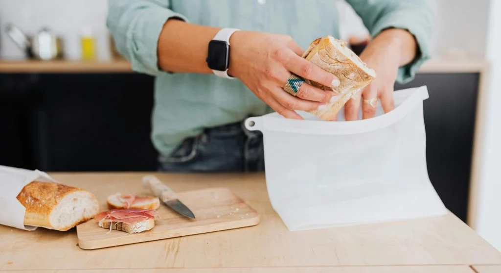 Freezing leftover bread by storing sliced bread in a freezer-safe bag to waste less food