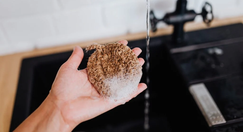 Reusable cleaning cloths within reach near a sink making low-waste cleaning easier