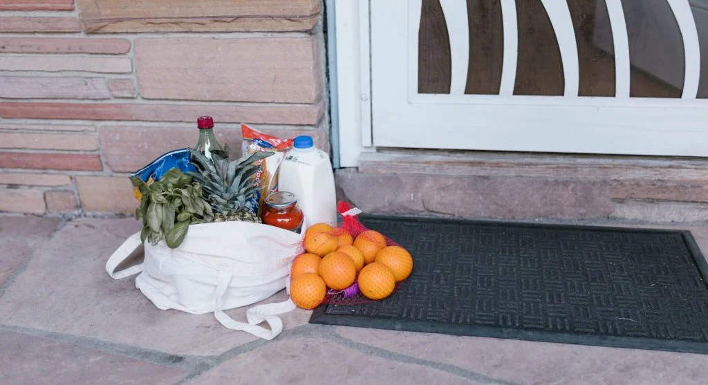 Keeping reusable shopping bags near the door by returning them to a visible entryway spot after shopping