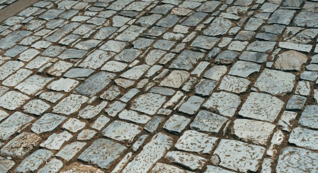 Small patch of shade over pavement reducing the heat of one section of a paved surface